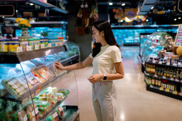 Young Woman Choosing Groceries in Refrigerated Section of Supermarket