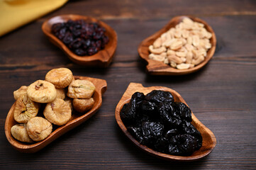 dried fruits prunes, figs, cranberries nuts in wooden bowls close-up