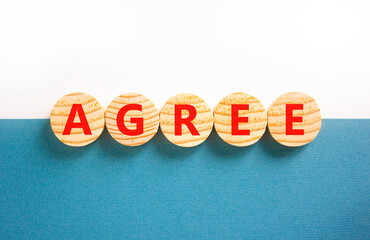 Agree symbol. Concept word Agree on beautiful wooden circles. Beautiful white and blue background....