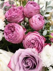 Close-up of fresh pink roses with lush greenery and white accents