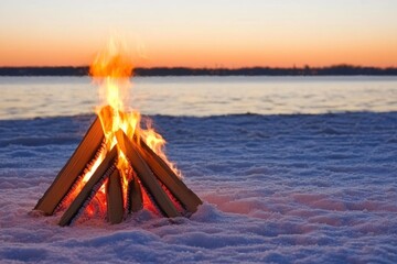 Fototapeta premium Winter campfire on snowy beach at sunset