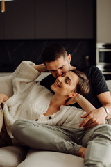 Happy couple relaxing and cuddling on sofa at home