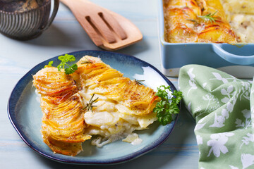 Potato and onion gratin on blue plate. Scalloped potatoes or potato bake