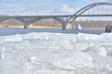 Ice blocks on the bank of the Volga with a view of the Rabinsky Bridge.