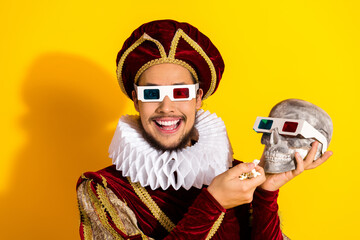 Obraz premium Smiling nobleman wearing 3D glasses on yellow background holding a skull