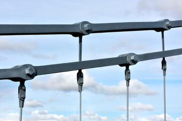 Links and suspensions of the chain bridge close-up against the background of the blue sky.