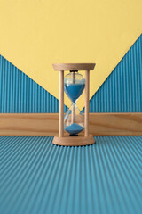 Hourglass with a flowing blue sand inside	