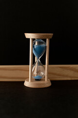 Hourglass with a flowing blue sand inside	