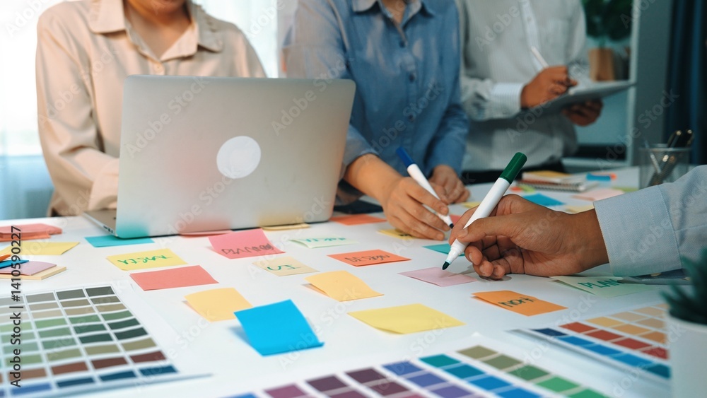 Poster a vibrant workspace setup showcasing a team collaborating with color swatches and notes, highlightin