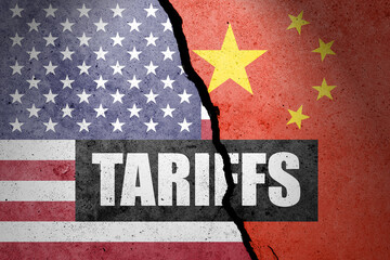 USA and China flags painted on the concrete wall with word TARIFFS. Duty, trade, customs and...