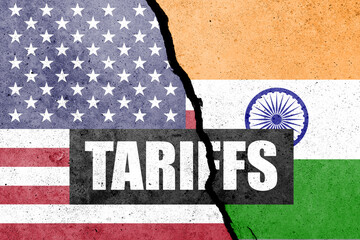 USA and India flags painted on the concrete wall with word TARIFFS. Duty, trade, customs and tariffs war