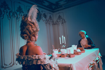 Elegant couple in historic costumes enjoys unique fusion dinner under ambient blue neon light