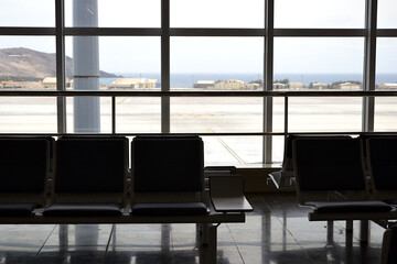 Airport lounge. Empty airport terminal seating area with a large window view. Travel concept -...