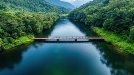 A serene wooden bridge spans an emerald river, surrounded by lush greenery, highlighting the harmony between nature and human construction in a tranquil setting.
