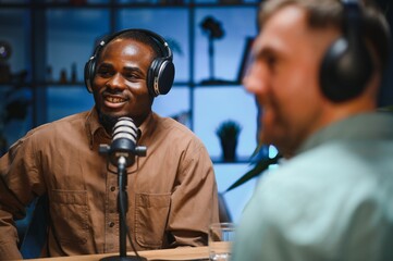 Man recording podcast using high tech microphones to interview guest, ensuring flawless video and...