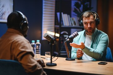 Man recording podcast using high tech microphones to interview guest, ensuring flawless video and...