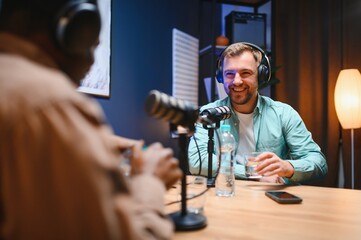 Man recording podcast using high tech microphones to interview guest, ensuring flawless video and...