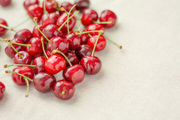 Fresh red cherries on beige fabric
