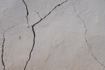 Cracked plaster wall surface with visible damage
