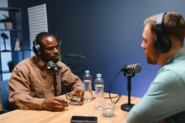 Man recording podcast using high tech microphones to interview guest, ensuring flawless video and...