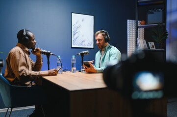 Show host and guest meeting to stream podcast episode together, creating online content with live...