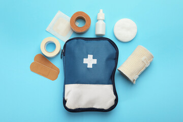 First aid kit. Different medical supplies on light blue background, flat lay