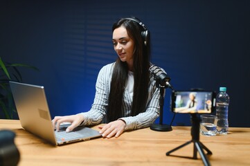 Smiling young caucasian girl woman making a video blog with camera