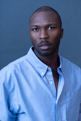 Fototapeta premium Portrait of a man with a blue shirt against a simple background