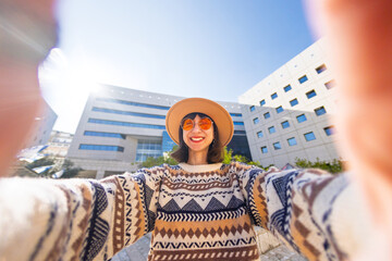 girl takes a selfie. a woman in a fashionable style takes a photo of herself on a smartphone while...