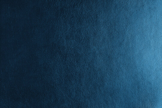 Glossy structure of genuine leather with gradient lighting effect, natural skin surface with embossing pattern. Artifical blue colored leatharette macro texture. Background, wallpaper, backdrop.