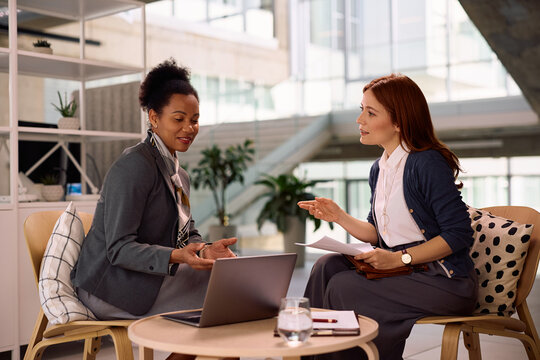 Black financial consultant and her client using laptop during a meeting in the office.