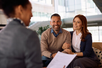 Happy couple having consultations with insurance agent in the office.