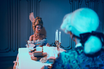 Elegant couple in vintage baroque attire dining in neon-lit historical theme setting indoors