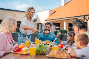 Happy family enjoying lunch together in the backyard garden