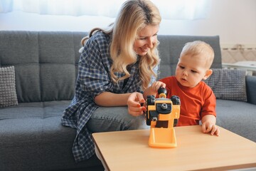 Mother and son playing with a toy truck at home
