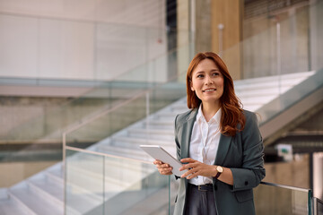 Happy female entrepreneur using touchpad while working in office.