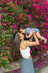 Mother holding her baby son as they bump nose to nose and the mother and baby smile