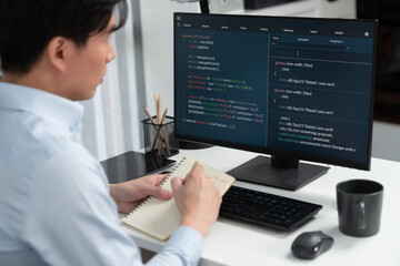 Smart IT developer looking at coding program application on computer screen of online website, analyzing intelligent database system development on business world market at modern office. Infobahn.