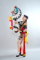 A traditional Javanese Jathilan dancer holds a flat horse puppet, wearing a vibrant costume with rich embroidery, symbolizing the spirit and heritage of Indonesian folklore art.