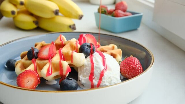 Pink berry topping topping on delicious Belgian waffles with fresh strawberries and blueberries and creamy ice cream. Strawberry cheesecake dip on Viennese waffles with a scoop of vanilla ice cream.