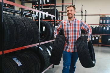 Man chooses winter car tires in the auto shop