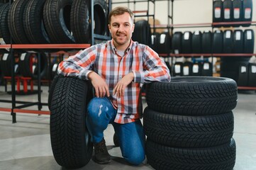 man to choose tires in car store
