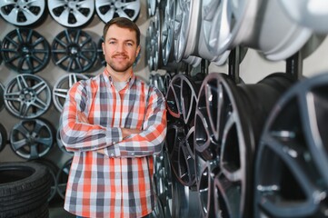 Obraz premium male customer choosing alloy wheel rims at car repair service or auto store