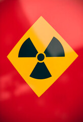 yellow and black hazard sign on a red surface