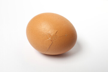 One egg with cracked shell on white background, closeup