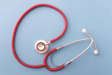 Stethoscope on blue background, top view. Space for text