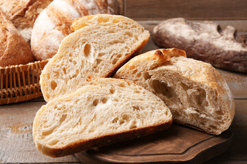 Slices of fresh bread on wooden table, closeup