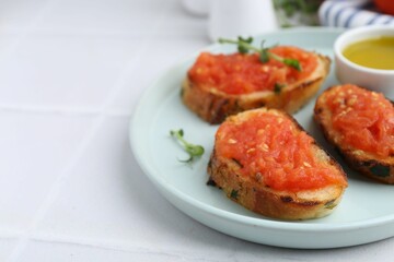 Tasty bread with tomato, microgreens and oil on white table, closeup. Space for text