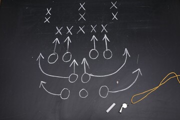 Chalk and whistle on chalkboard with scheme of American football game, flat lay
