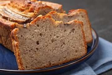 Cut banana bread with nuts on table, closeup